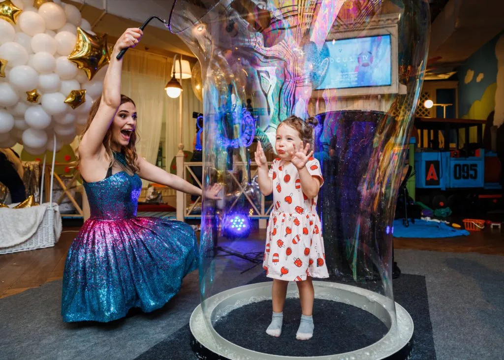 Child taking part in a giant bubble show